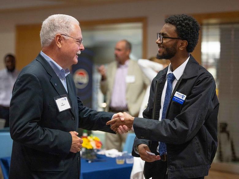 Student shaking hand with a person